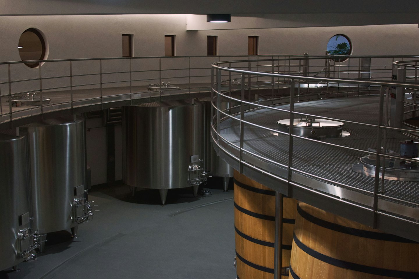 Serbatoi di fermentazione in acciaio inox e botti di legno riempiono una moderna cantina.